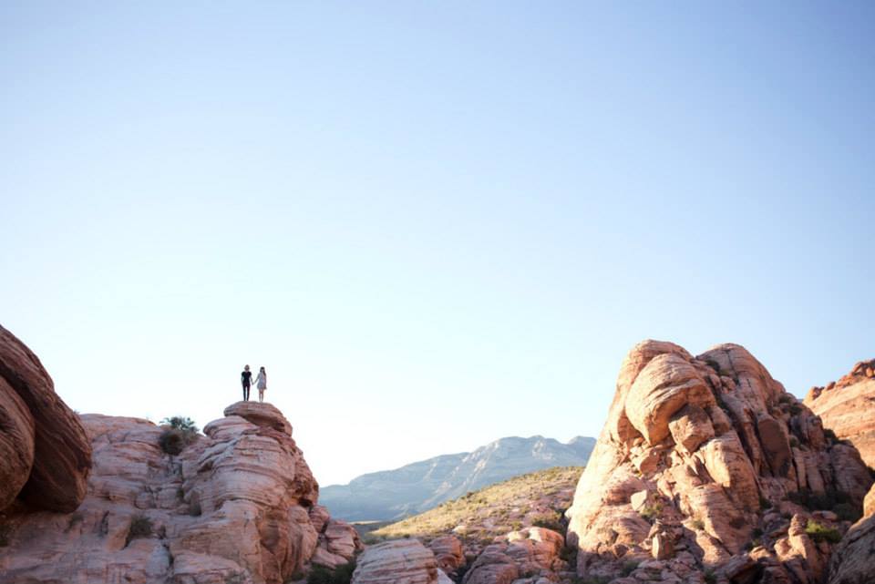 Couple in love standing on a tall rock.