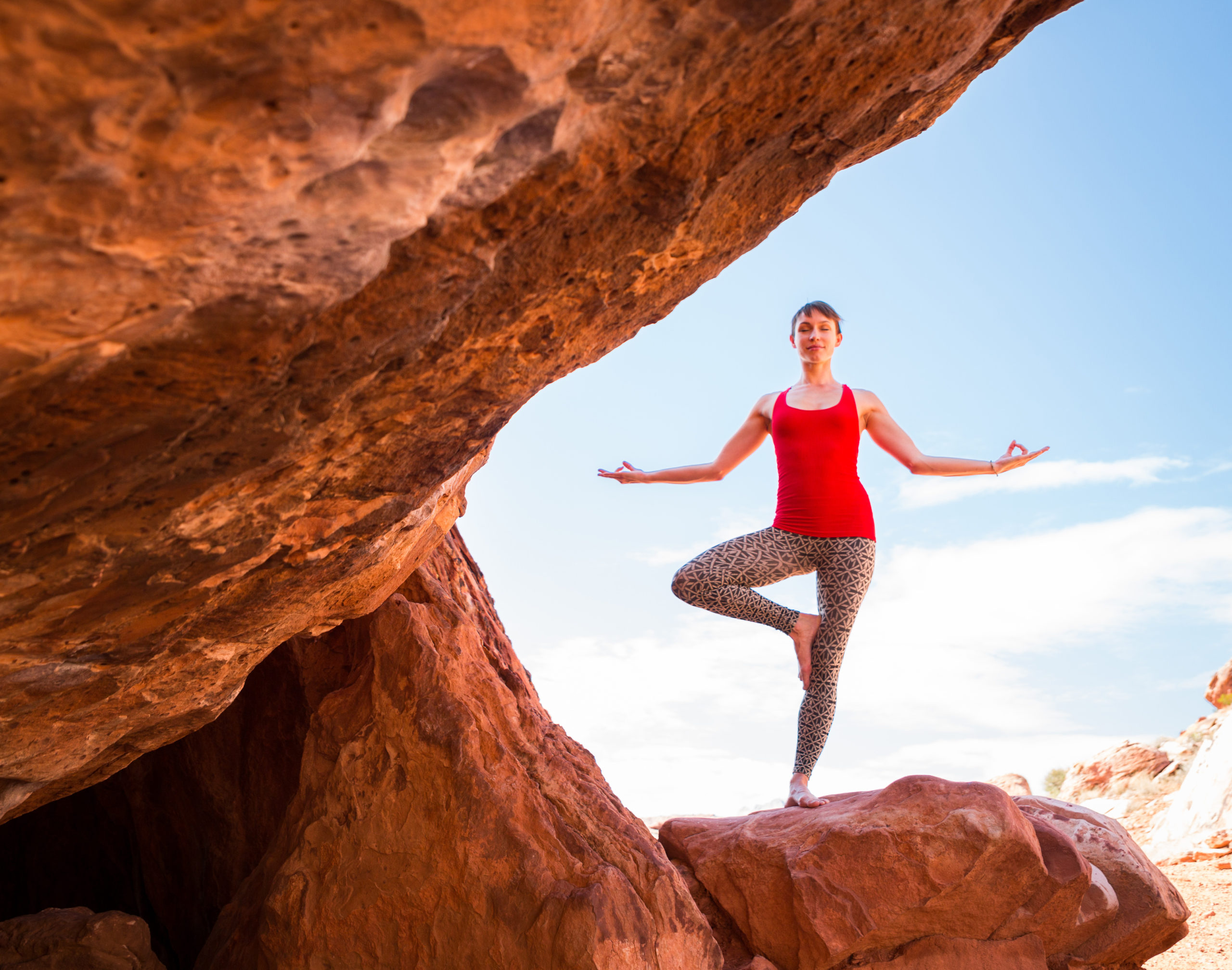 Woman on rock practicing yoga pose.