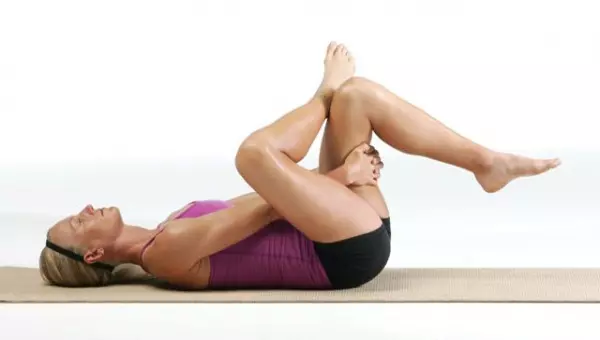 Woman demonstrating figure 4 stretch.