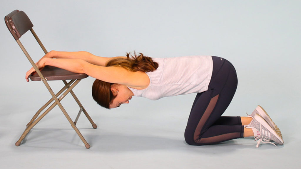 Woman demonstrating lat climbing stretch