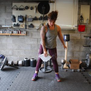 Women demonstrated a grip strength exercise using thick bumper weight plate