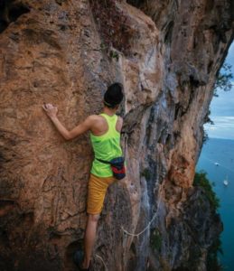 Woman rock climbing using the Free Soloing style.
