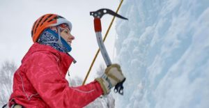 Woman using pick to ice climb.