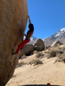 woman rock climbing in red pants
