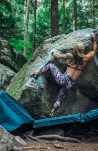 woman rock climbing wearing colorful rock climbing pants