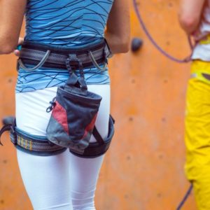 Woman wearing rock climbing harness and chalk bag around her waist.