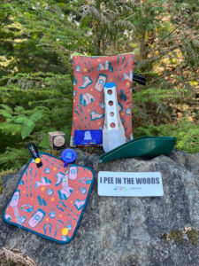 Several products from Kula Cloth resting on a rock in the woods, including pee cloths.
